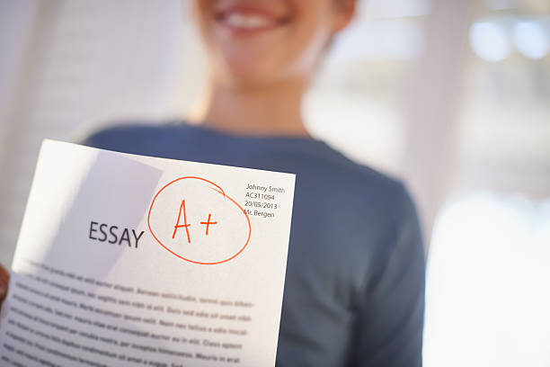 Young student with essay paper graded A+