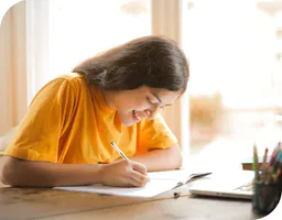 Woman writing in a text book